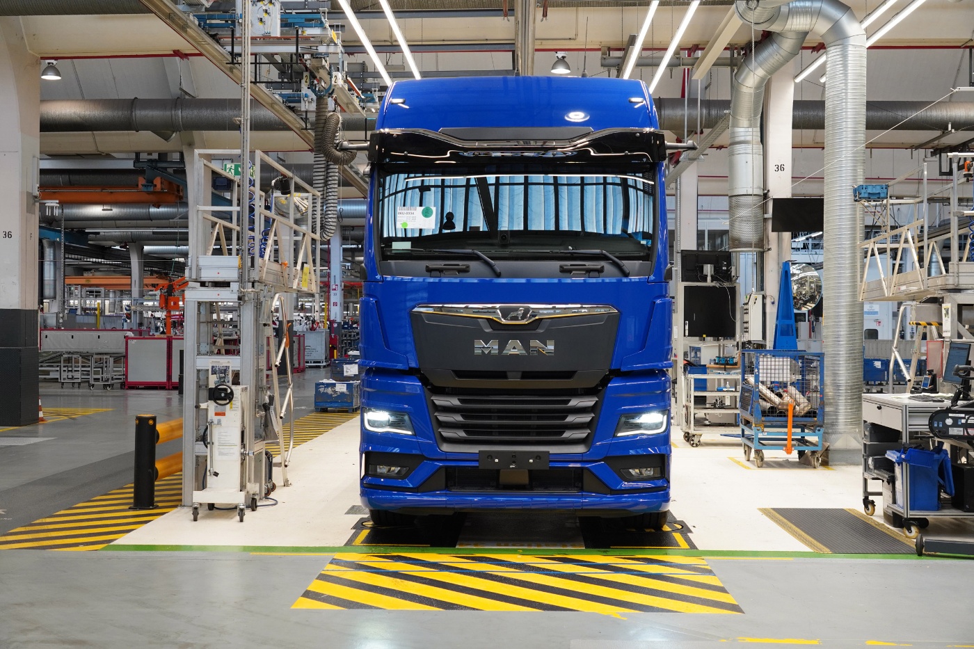 Blue MAN truck on a production line inside a modern manufacturing plant.