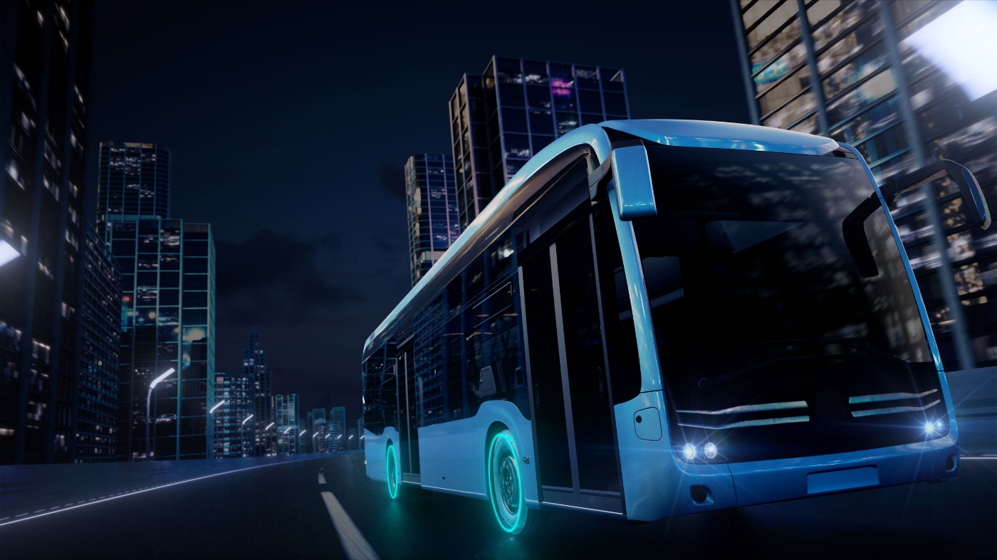 Elektro-Stadtbus fährt nachts durch eine Stadt.