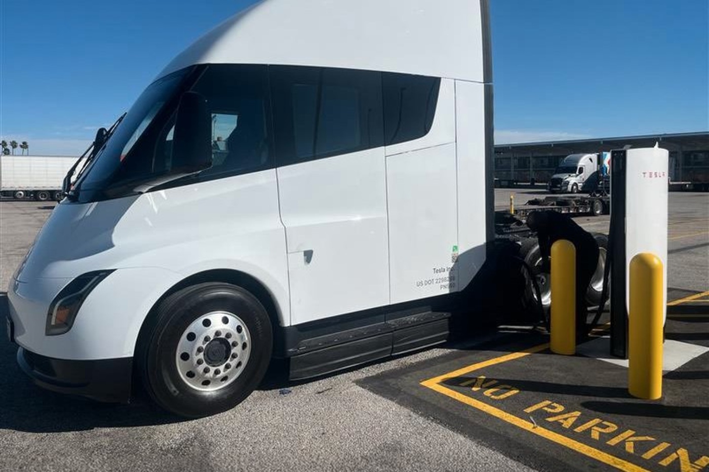 Weißer Tesla Semi beim Laden an einer Tesla-Ladestation.