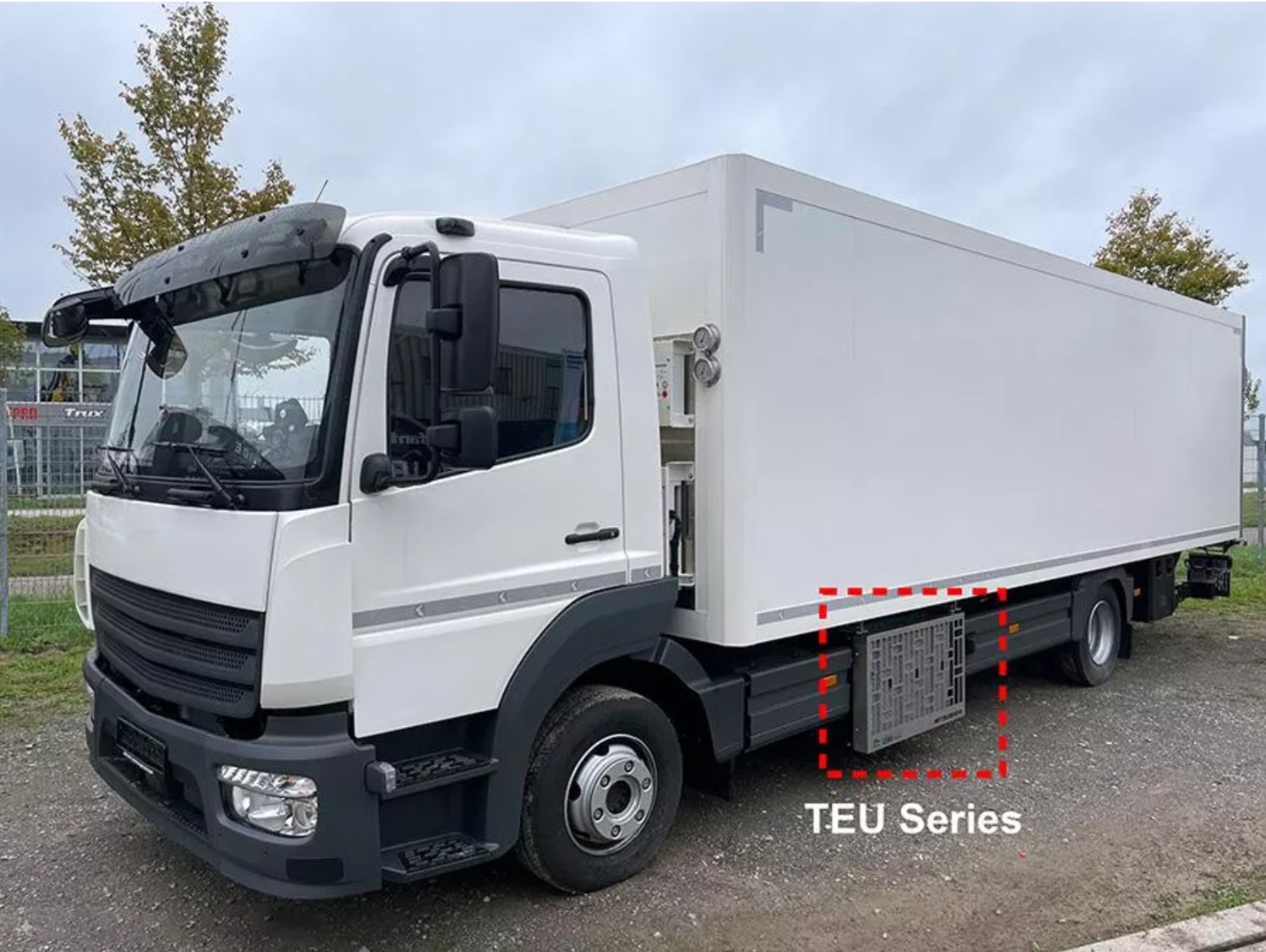 Weißer Mitsubishi Heavy Industries Koffer-Lkw mit seitlich montierten TEU-Boxen.