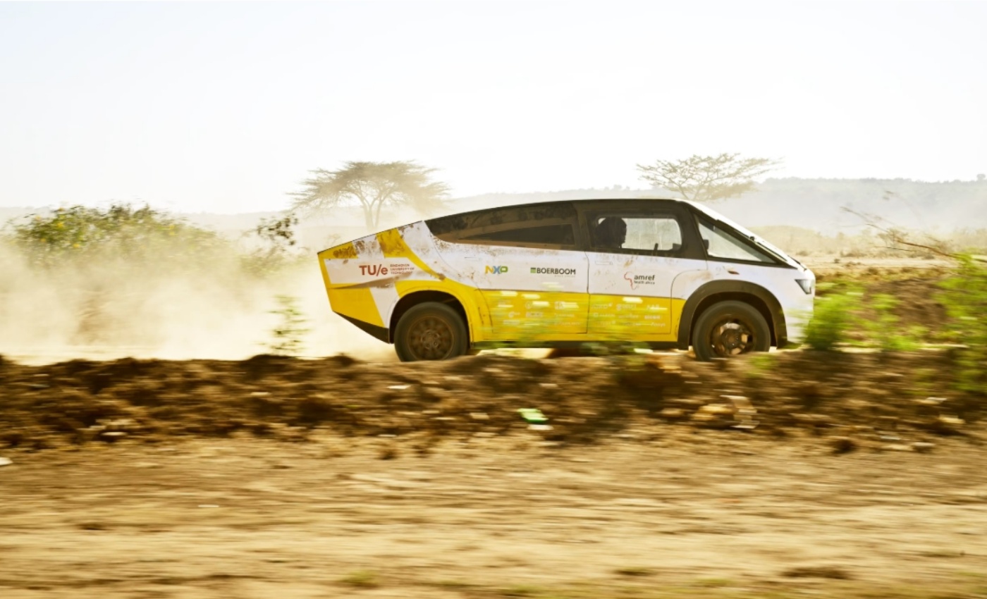 Fahrzeug des Solar Team Eindhoven fährt auf einer staubigen unbefestigten Straße.