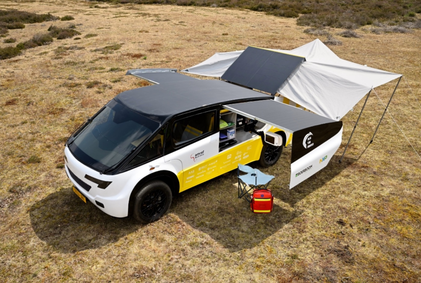 Fahrzeug des Solar Team Eindhoven mit ausgeklapptem Campingzelt in trockener Landschaft.