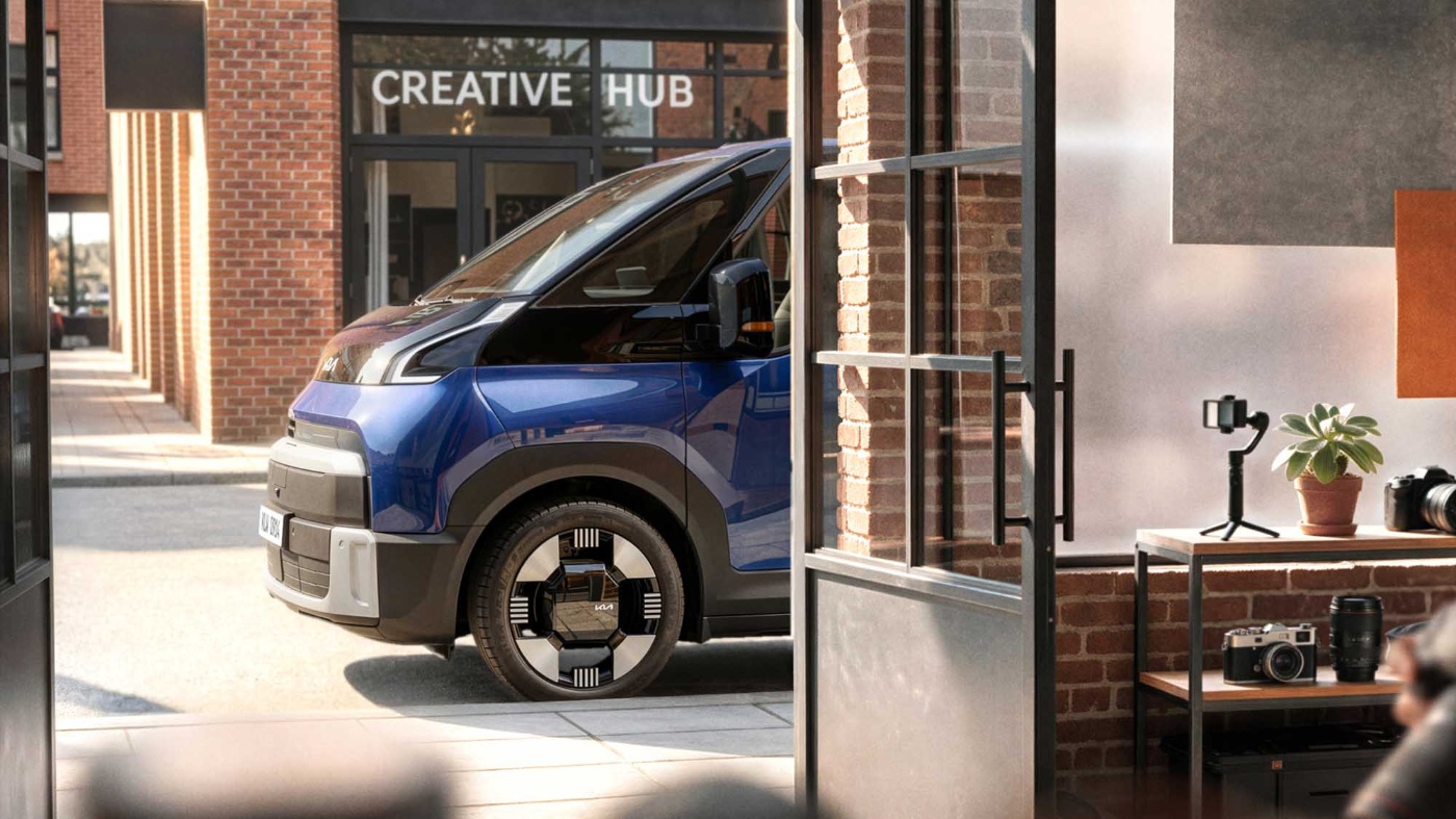 Blauer Kia PV7 vor einem Creative Hub.