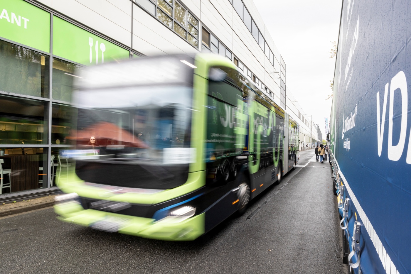 Grüner Stadtbus auf einer Straße nahe dem Messegelände.